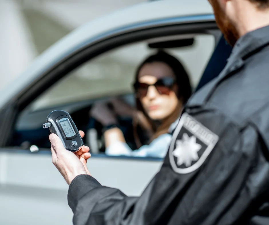 A policeman holding a breathalyzer test